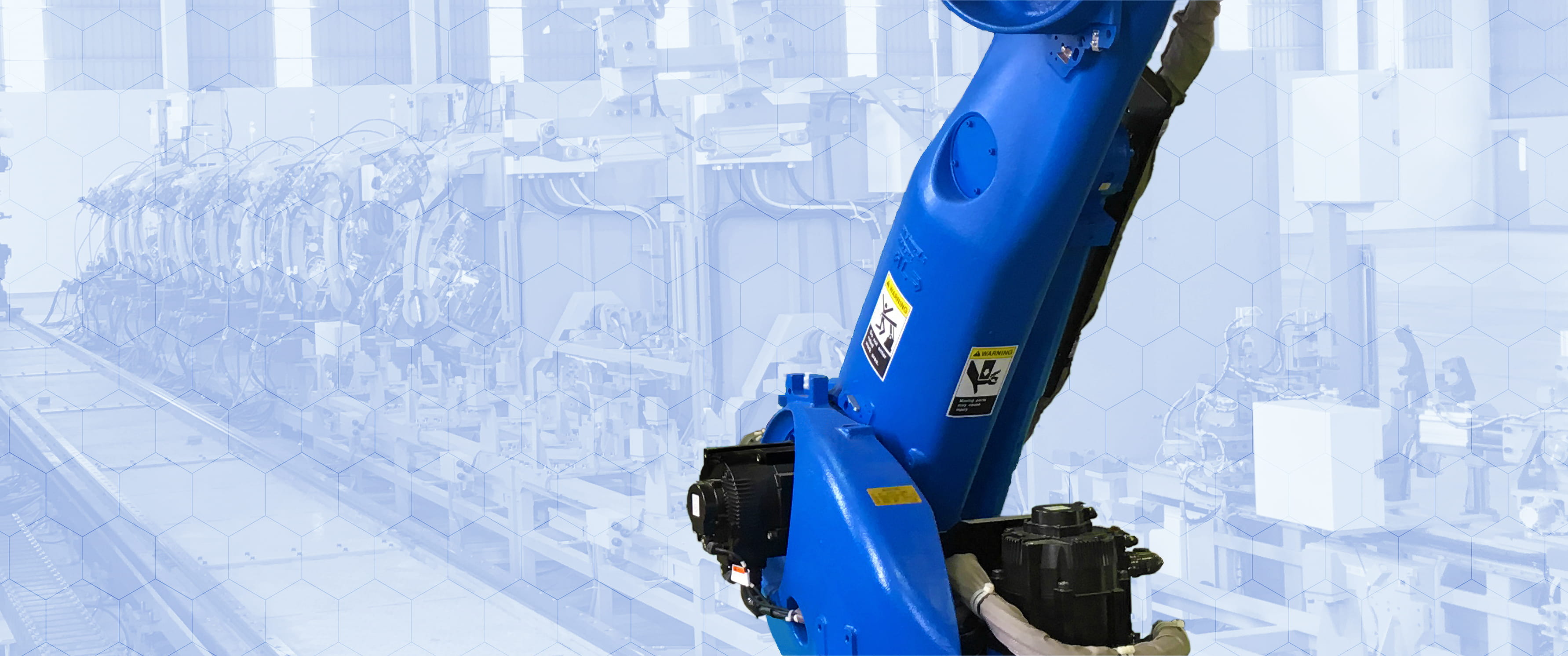 青い機体の自動ロボットが、製造工場内のレールを動きながら作業をしている様子