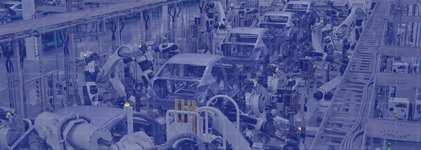 大型の自動ロボットが車の製造工場で稼働する様子
