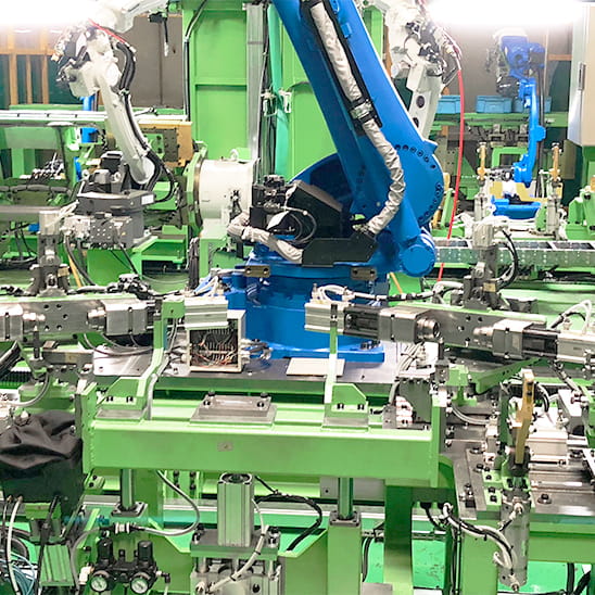 青い機体の大型アームロボットが稼働している製造工場の様子